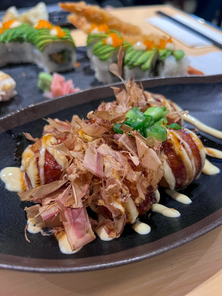 Takoyaki balls topped with white and brown sauces