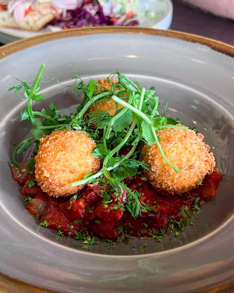 Goats cheese bon bons on a bed of tomato sauce