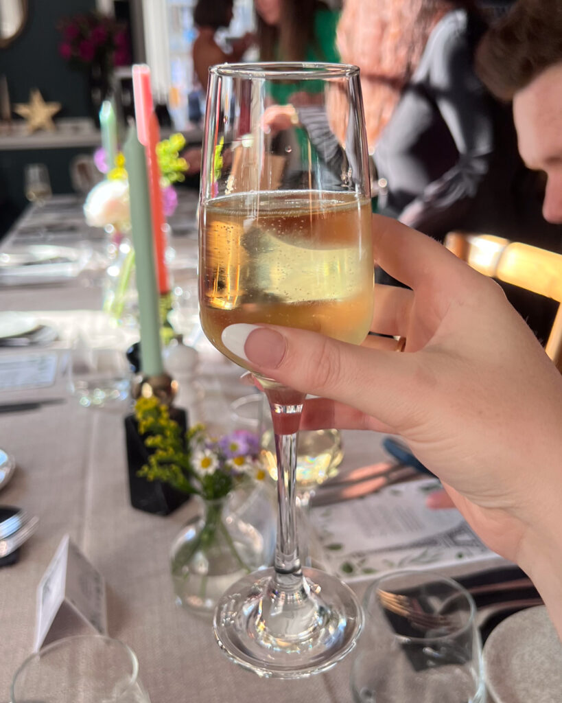 Holding champagne in front of fancy table setting at Le Bistrot