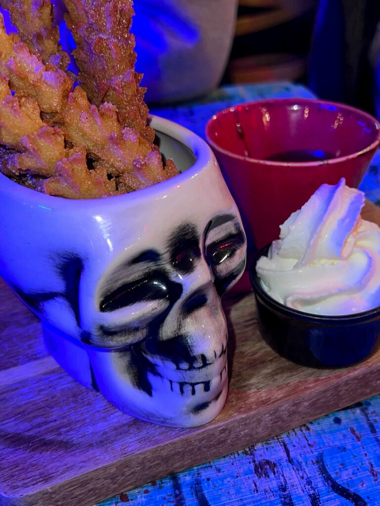 Skull jar with churros and whipped cream on the side