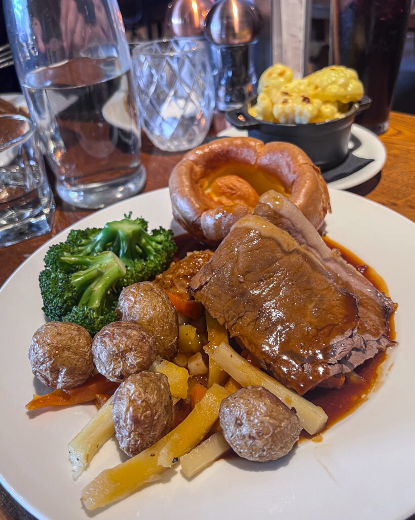 Roast beef, yorkshire pudding, potatoes and vegetables on a plate