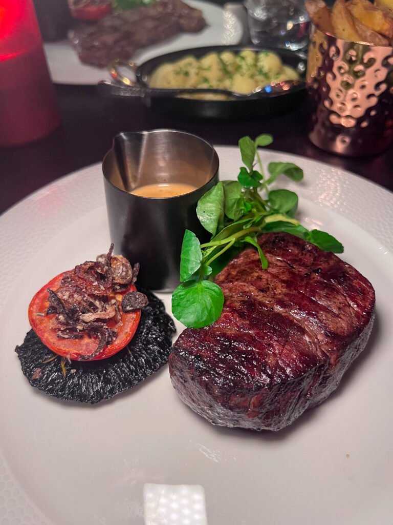 Fillet steak, mushroom, tomato, sauce and garnish on a place from The Merchant Steakhouse