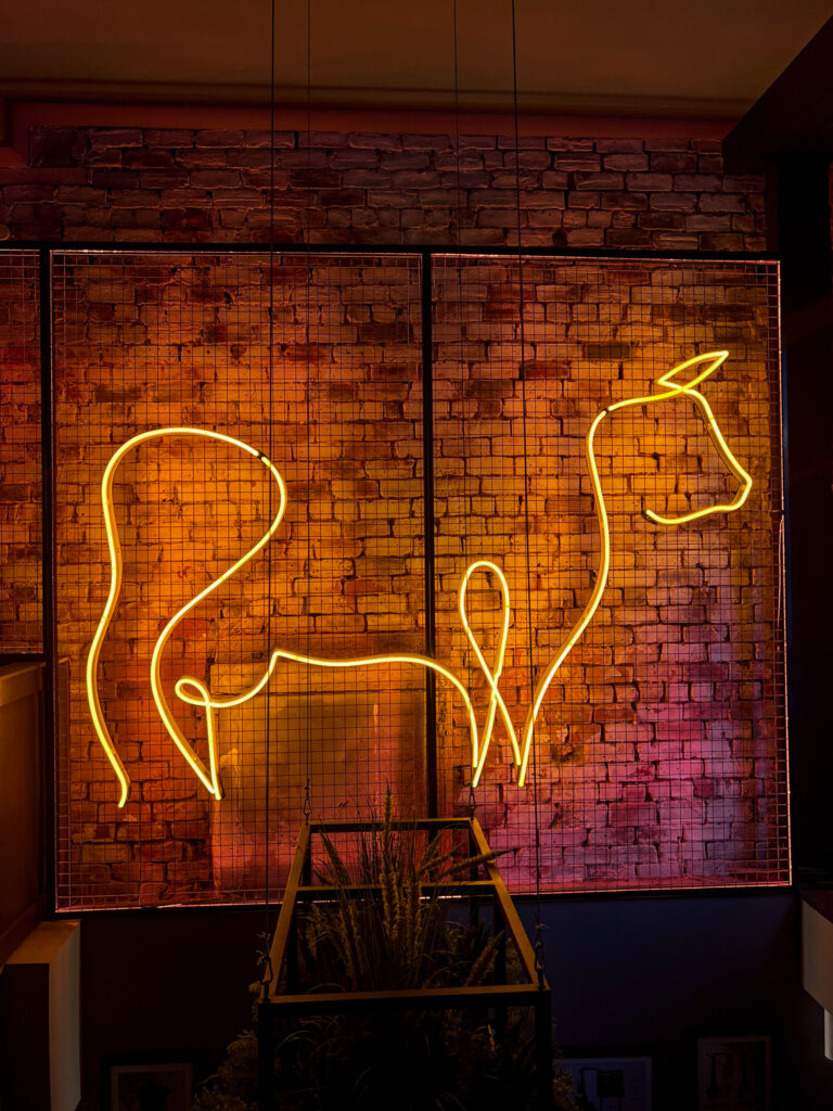 Cow neon sign in shape of The Merchant Steakhouse logo