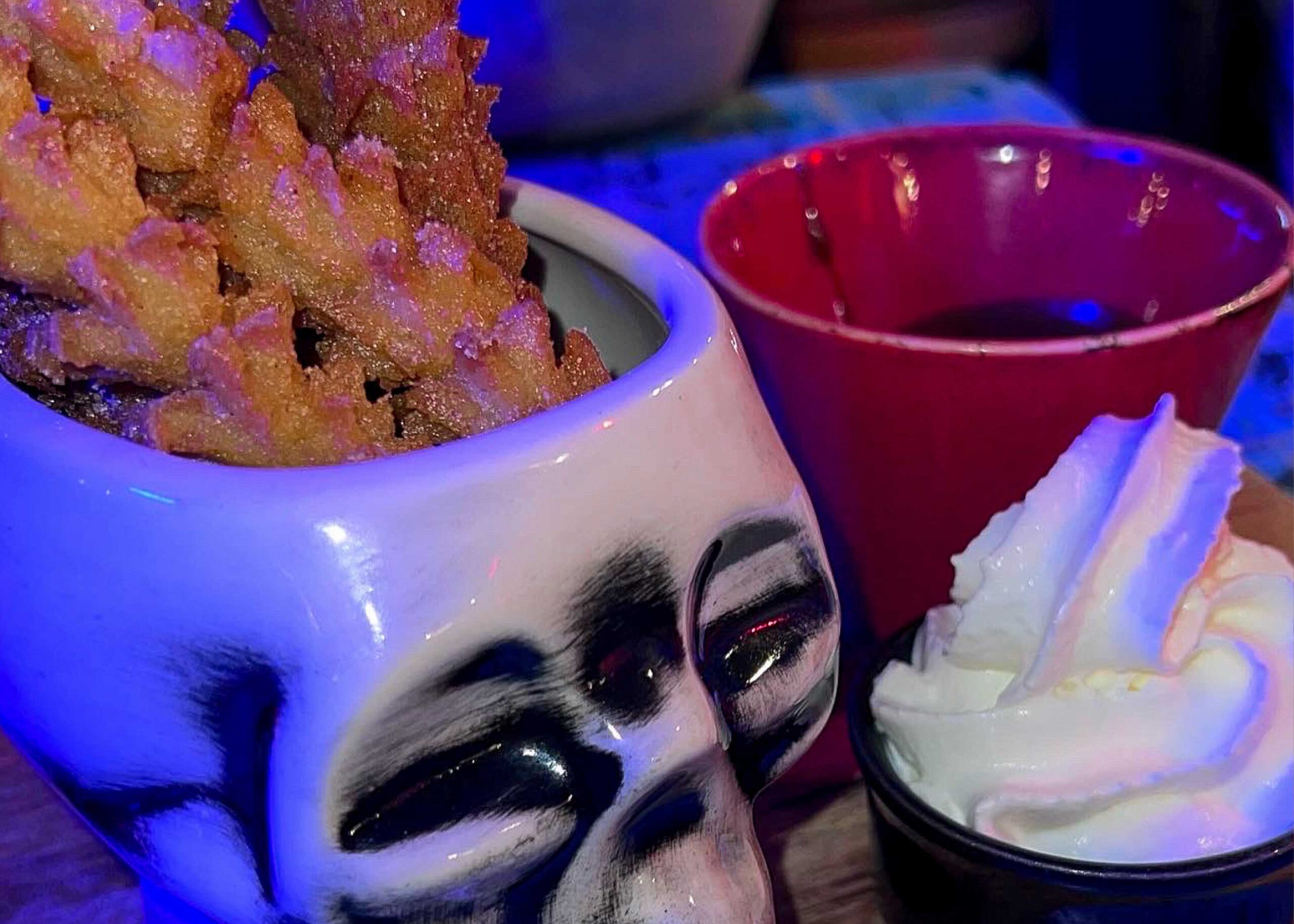 Skull jar filled with churros with a top of whipped cream beside it