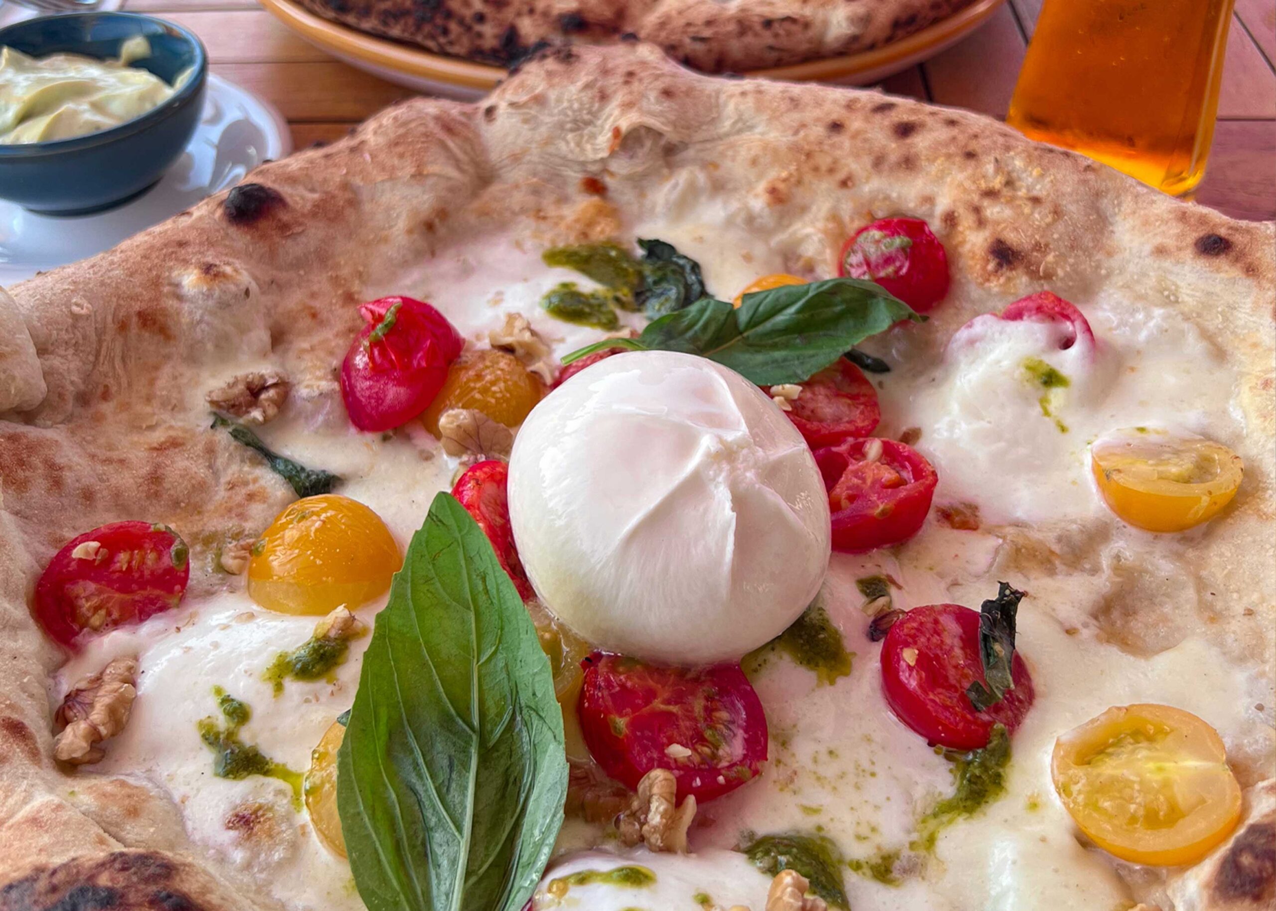 White base pizza topped with tomatoes, basil and burrata from Napole Pizzeria